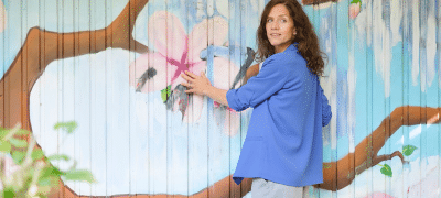 Förderung der Resilienz, Stress-Resilienz steigern, Frau vor gemaltem Bild von Baum